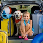 Mädchen mit Hund im Kofferraum